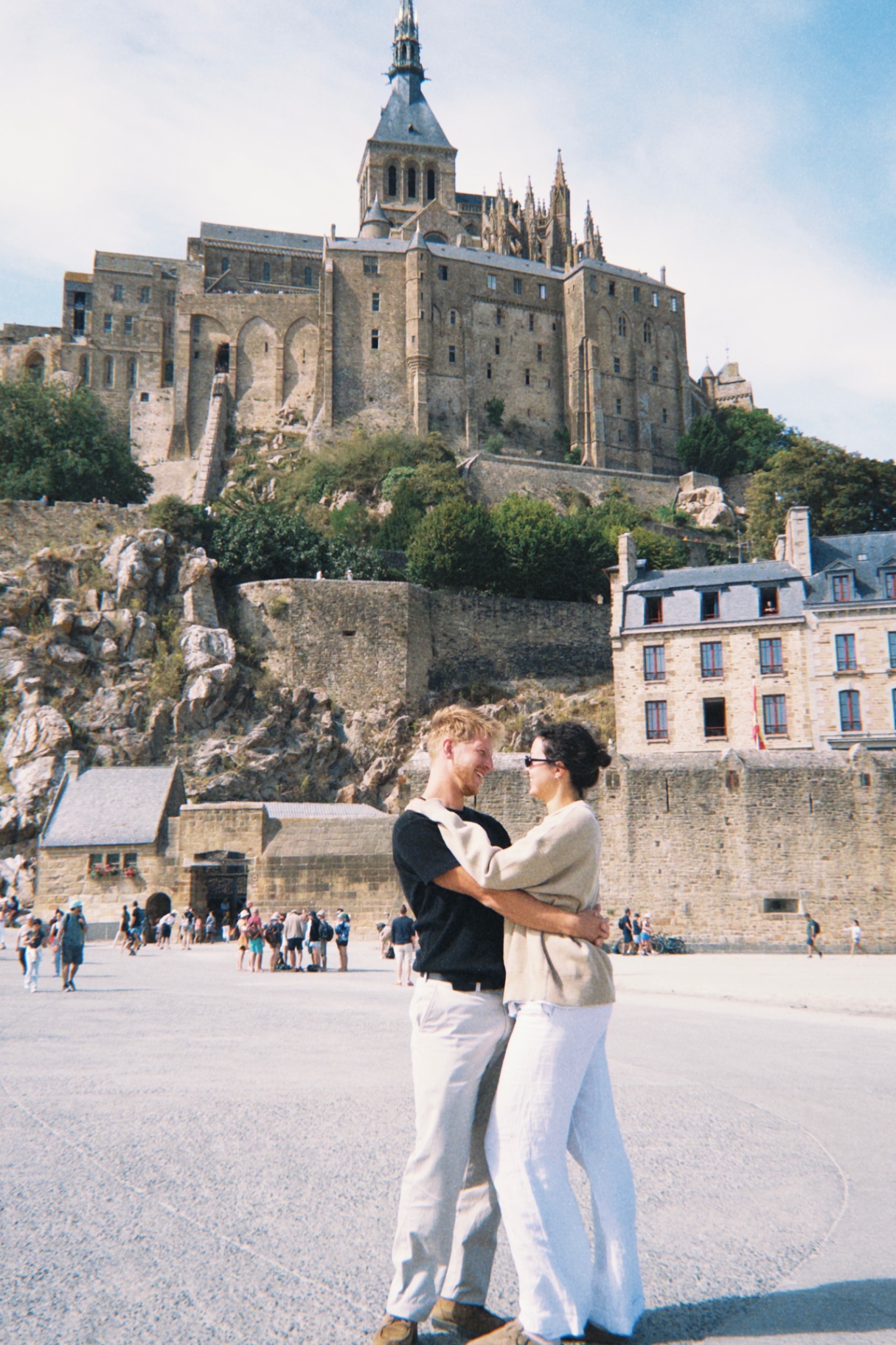 Jono & Monika embracing in front of Mont Saint-Michel